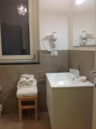 a bathroom with a sink and a mirror and a stool at Affittacamereirosmarini in Vernazza