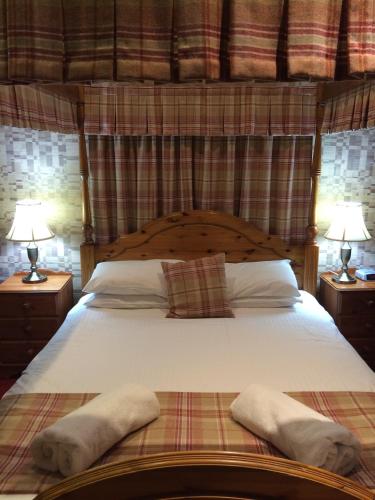a bedroom with a large bed with two lamps at The Panmure Arms Hotel in Edzell