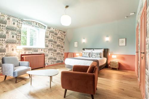 a bedroom with a bed and a couch and a chair at La Castagnère de Bergory in Wervicq-Sud