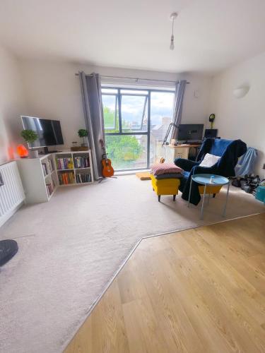 a living room with a large window and a couch at Cosy 1-bedroom apartment in Greater London in London