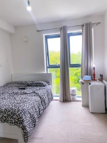 a bedroom with a bed and a large window at Cosy 1-bedroom apartment in Greater London in London