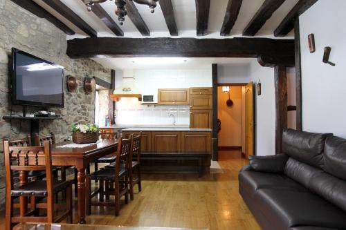 a kitchen and dining room with a table and a couch at Casa Rural Iratxeko-Berea in Bera