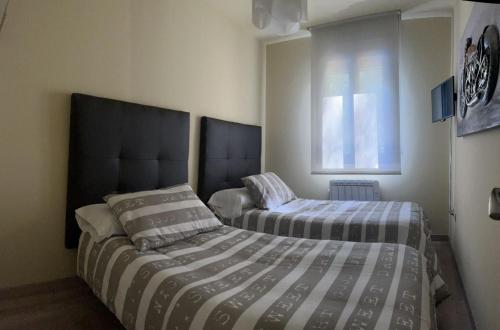 1 dormitorio con 2 camas y ventana en Apartamento Vida en Arenas de San Pedro