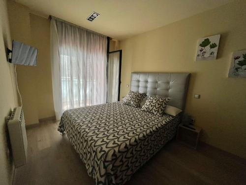 a bedroom with a bed and a large window at Apartamento Vida in Arenas de San Pedro