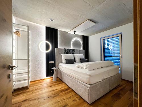 a bedroom with a large white bed and a window at Mid Mountain Apartment Tirol in Wiesing