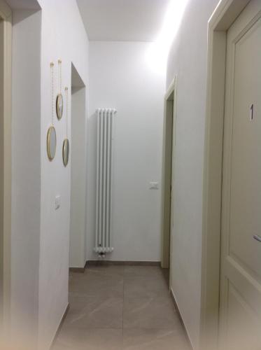 a hallway with a white wall and a radiator at Affittacamereirosmarini in Vernazza