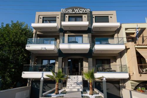 een gebouw met palmbomen ervoor bij Blue Wave Luxury Suites in Iraklitsa