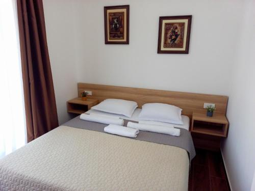 a bedroom with a bed with two white pillows at Iraida-4 in Dobra Voda