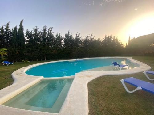 a large swimming pool with two chairs and a table at Chalet Brisas del Mar in Chiclana de la Frontera