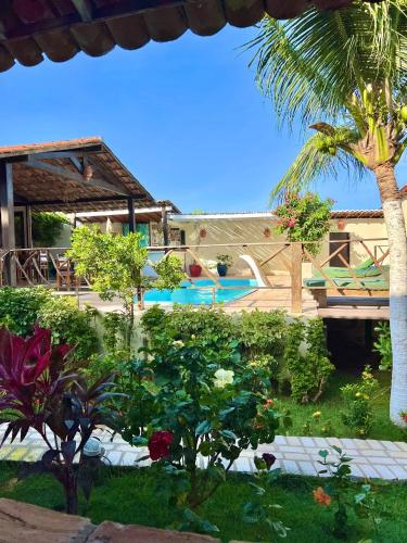 a resort with a swimming pool and a palm tree at Pousada da Renata in Jericoacoara