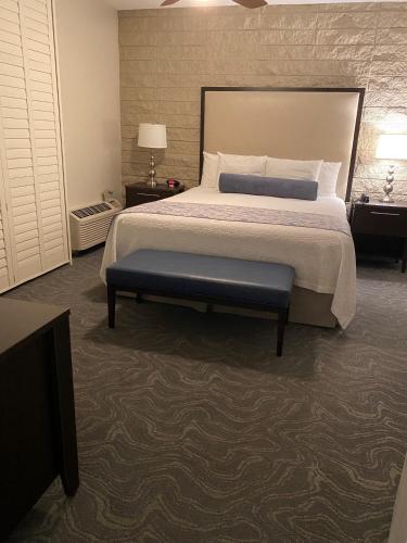a bedroom with a bed and a bench in it at GetAways at Palm Springs Tennis Club in Palm Springs