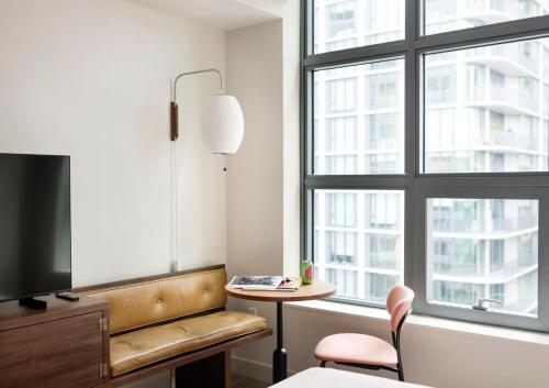 a room with a chair and a table and a window at ROOST Tampa in Tampa