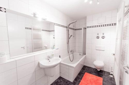 a white bathroom with a sink and a tub and a toilet at Private apartment in the center of Berlin in Berlin
