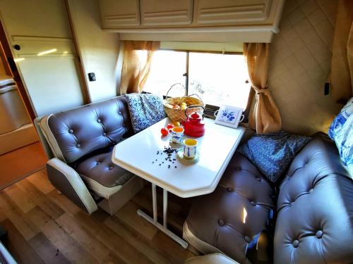 uma sala de estar com uma mesa e um sofá em Rent a BlueClassics 's Campervan le Voyageur In Algarve au Portugal em Portimão