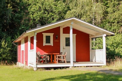 a red and white shed with a porch at Bergakungen Stugby in Osby