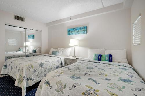 a bedroom with two beds and a mirror at Carousel 1605 in Ocean City