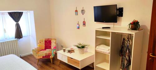a room with a bed and a tv and a chair at Hypnos Sleep and Go in Benevento