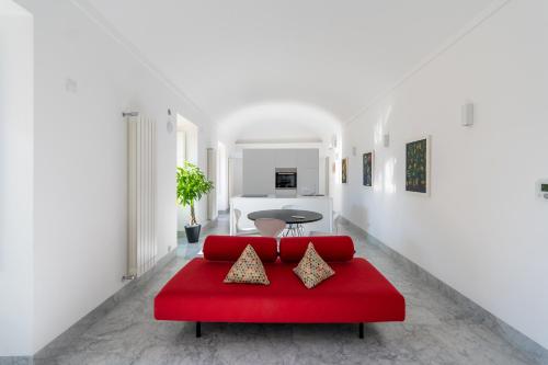 een rode bank in een kamer met witte muren bij Suite Bellini 5 Apartment in Palermo