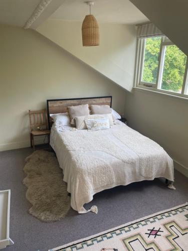 a bedroom with a large bed with a rug at The Loft, Farnham, Surrey in Farnham