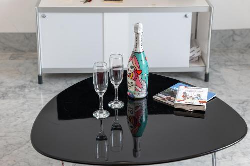 a table with two glasses and a bottle of wine at Suite Bellini 5 Apartment in Palermo