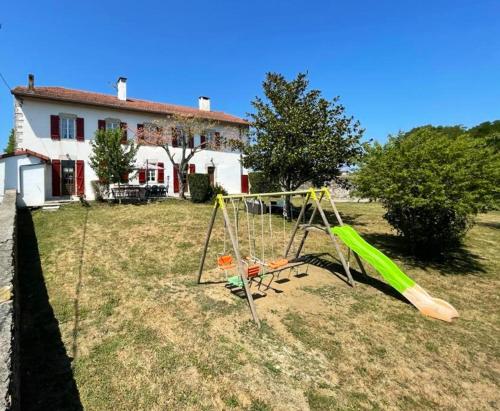 a swing set in a yard in front of a house at Maison confortable à Bardos avec vue sur montagne in Bardos
