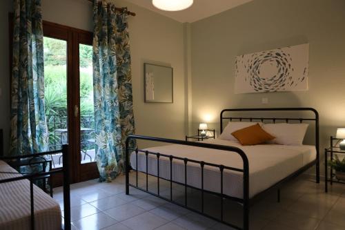 a bedroom with a bed and a window at Island Boutique Apartments in Pyrgadikia