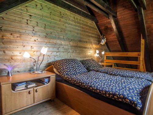 1 dormitorio con 1 cama y pared de madera en Chalet Drevarska en Benecko