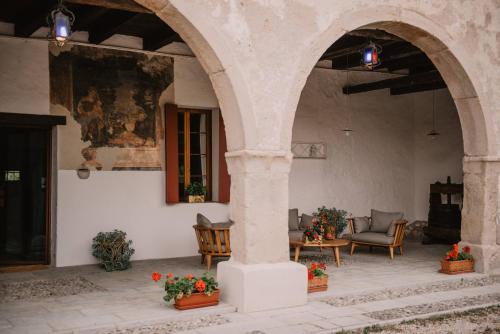 un patio esterno con due archi e un tavolo con fiori di Al Vecchio Convento-Tenuta Malvolti a San Fior di Sopra