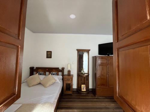 a bedroom with a bed and a dresser and a television at Casa Grande in Medellín