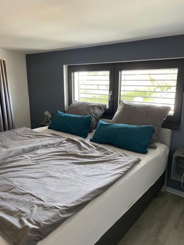 a bed with two blue pillows on top of it at Strandkieker 4 nur 500m zum Strand in Ueckermünde