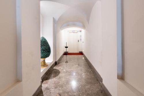 a hallway with white walls and a hallway with vases at Suite Bellini 5 Apartment in Palermo