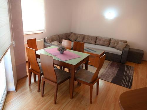 a living room with a table and chairs and a couch at MB Apartments in Jagodina