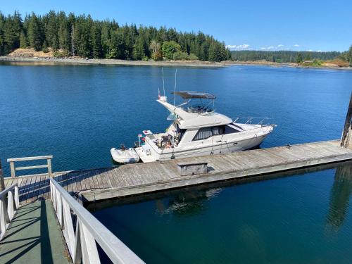 a boat is docked at a dock on a lake at April Point Harbour House in Quathiaski Cove