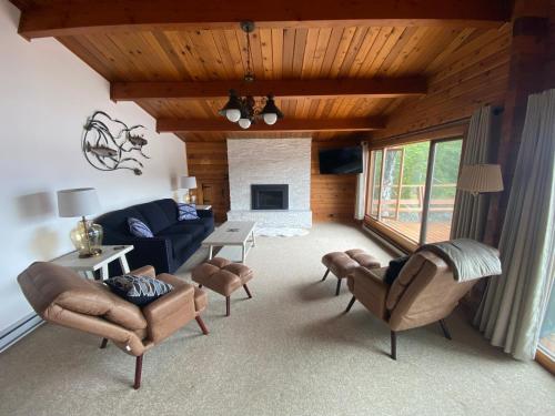 a living room with a couch and chairs and a fireplace at April Point Harbour House in Quathiaski Cove