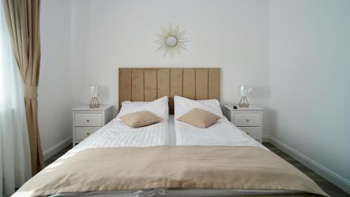 a bedroom with a large bed with two night stands at Casa Canadiana in Baile Felix