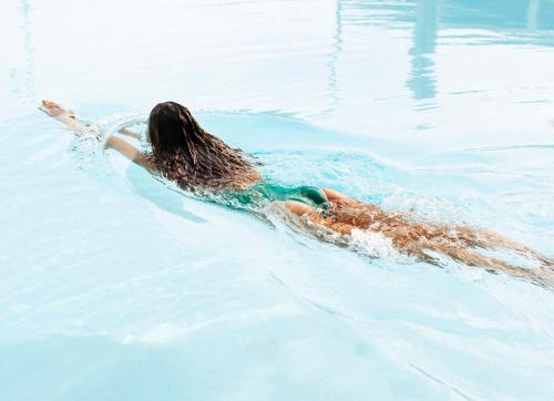 a woman swimming in the water in a pool at ROOST Tampa in Tampa