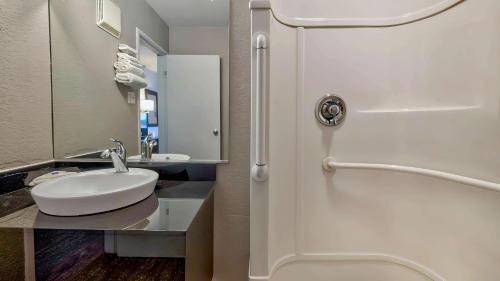 a bathroom with a sink and a white shower door at Motel 6-Santa Rosa, NM in Santa Rosa