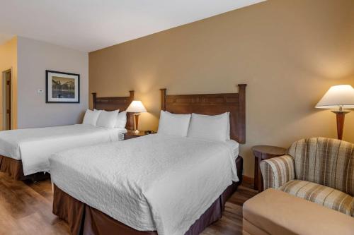 a hotel room with two beds and a chair at Best Western Desert Inn in West Yellowstone