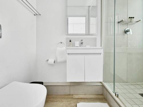 a white bathroom with a toilet and a glass shower at Cozy, Work Station, Wi-Fi, Patio in Cape Town