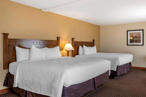 a hotel room with two beds and two lamps at Best Western Desert Inn in West Yellowstone
