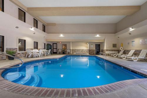 a pool in a hotel with chairs and tables at Best Western Desert Inn in West Yellowstone