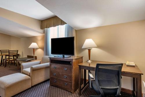 a hotel room with a television and a desk and chair at Best Western Desert Inn in West Yellowstone
