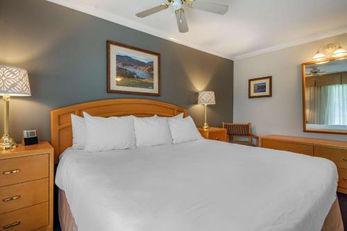 a bedroom with a large white bed and two lamps at Best Western Inn at Penticton in Penticton