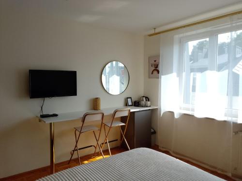a bedroom with a bed and a desk with a television at Alexa d'Oro Rooms in Krakow