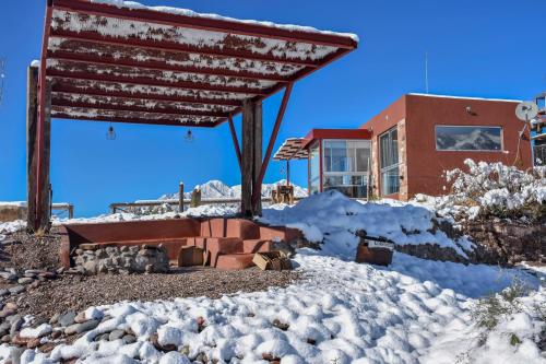 a building with snow on the ground in front of it at Potre casas de montaña in Potrerillos