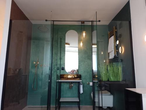 a bathroom with a sink and a glass shower at Alexa d'Oro Rooms in Krakow