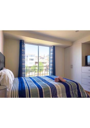 a bedroom with a bed and a large window at Buena Vista Apartment in Cusco