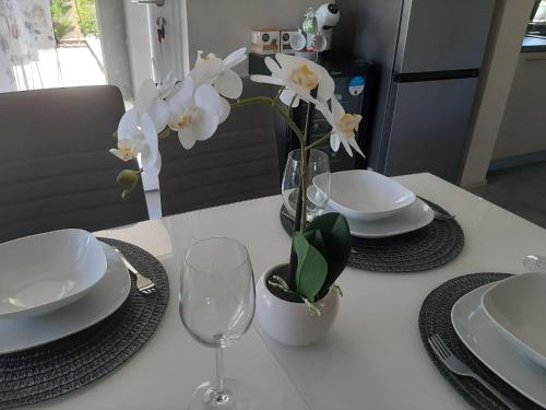 a table with plates and a vase with white flowers at Villa Jazz - Island Krk SPA Oasis in Krk