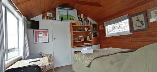 een slaapkamer met een bed in een kamer met houten plafonds bij Garden Cottage in Hastings