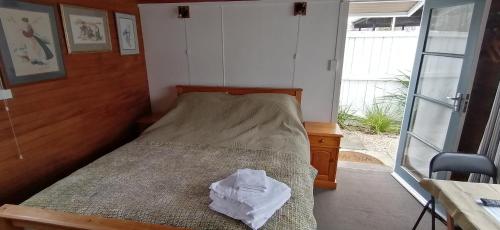 a bedroom with a bed with a pillow on it at Garden Cottage in Hastings